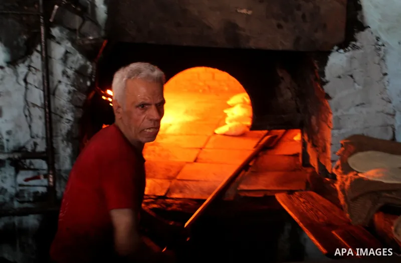 A Palestinian baker makes bread using a wood-fired oven at his traditional bakery in Rafah in the southern Gaza strip, on January 14, 2017. Power shortages in the Palestinian enclave have occurred repeatedly in recent we...