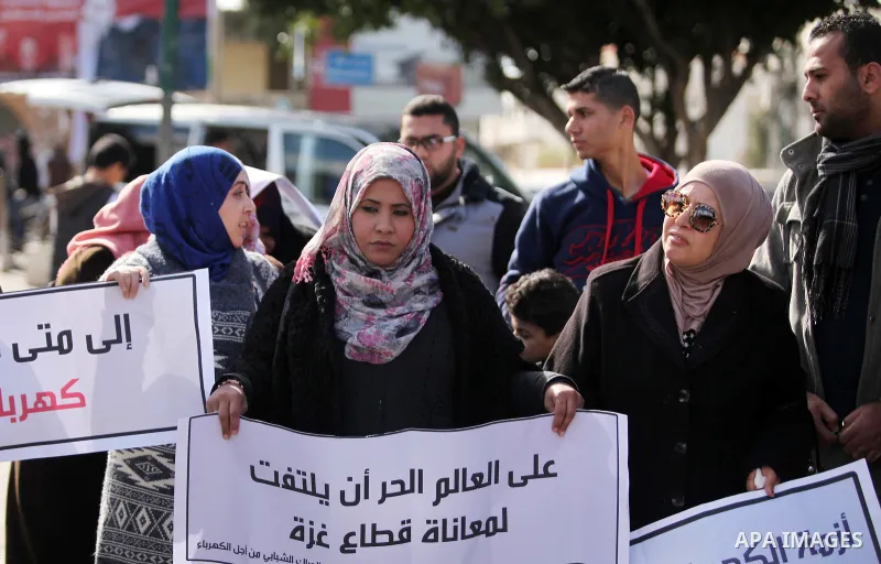 Palestinians hold placards during a demonstration against the ongoing electricity shortages in Gaza city on January 15, 2017. Power shortages in the Palestinian enclave have occurred repeatedly in recent weeks, with home...