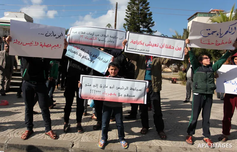 Palestinians hold placards during a demonstration against the ongoing electricity shortages in Gaza city on January 15, 2017. Power shortages in the Palestinian enclave have occurred repeatedly in recent weeks, with home...