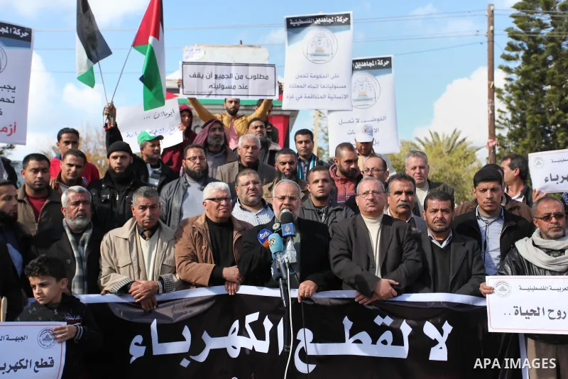 Palestinians hold placards during a demonstration against the ongoing electricity shortages in Gaza city on January 15, 2017. Power shortages in the Palestinian enclave have occurred repeatedly in recent weeks, with home...