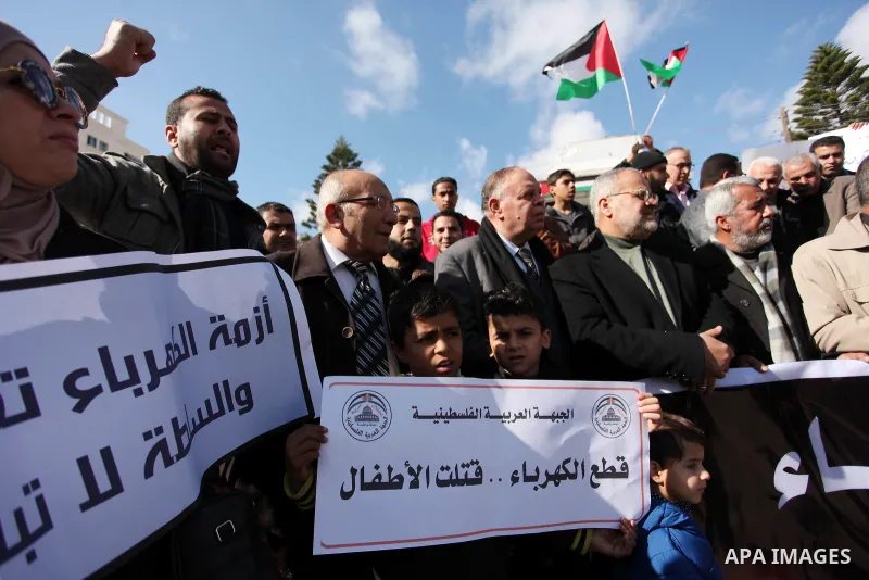 Palestinians hold placards during a demonstration against the ongoing electricity shortages in Gaza city on January 15, 2017. Power shortages in the Palestinian enclave have occurred repeatedly in recent weeks, with home...