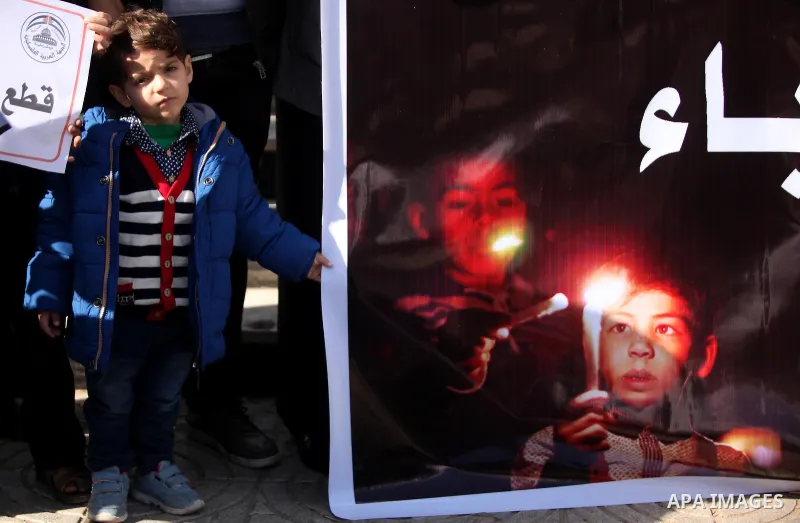 Palestinians hold placards during a demonstration against the ongoing electricity shortages in Gaza city on January 15, 2017. Power shortages in the Palestinian enclave have occurred repeatedly in recent weeks, with home...