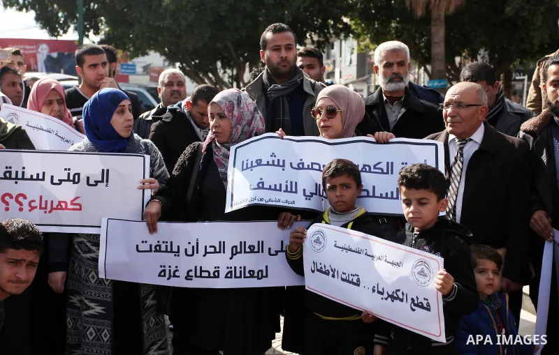 Palestinians hold placards during a demonstration against the ongoing electricity shortages in Gaza city on January 15, 2017. Power shortages in the Palestinian enclave have occurred repeatedly in recent weeks, with home...