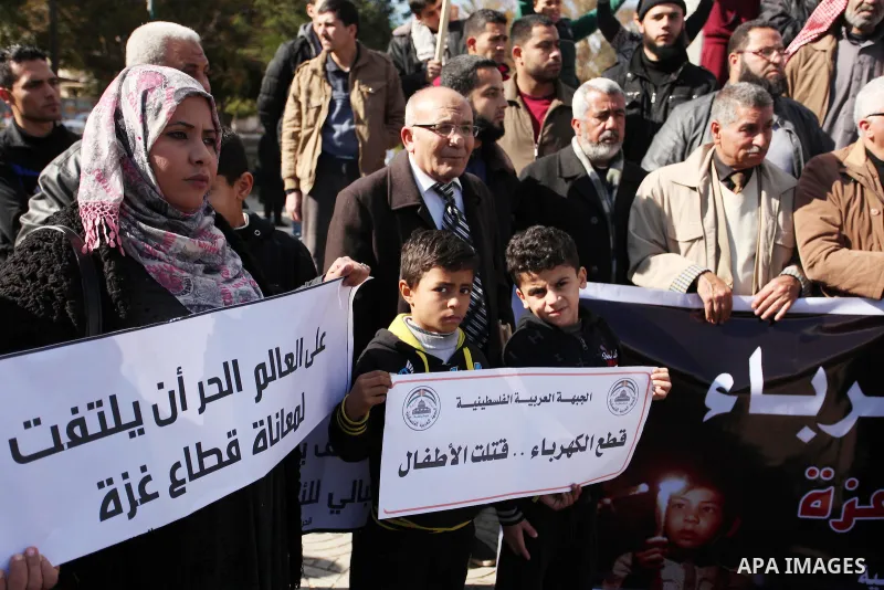 Palestinians hold placards during a demonstration against the ongoing electricity shortages in Gaza city on January 15, 2017. Power shortages in the Palestinian enclave have occurred repeatedly in recent weeks, with home...