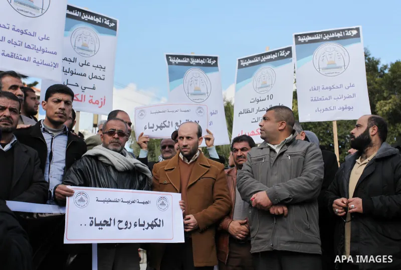 Palestinians hold placards during a demonstration against the ongoing electricity shortages in Gaza city on January 15, 2017. Power shortages in the Palestinian enclave have occurred repeatedly in recent weeks, with home...