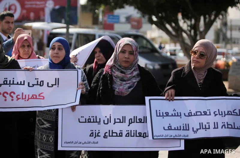 Palestinians hold placards during a demonstration against the ongoing electricity shortages in Gaza city on January 15, 2017. Power shortages in the Palestinian enclave have occurred repeatedly in recent weeks, with home...