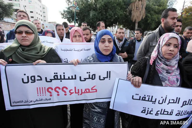 Palestinians hold placards during a demonstration against the ongoing electricity shortages in Gaza city on January 15, 2017. Power shortages in the Palestinian enclave have occurred repeatedly in recent weeks, with home...