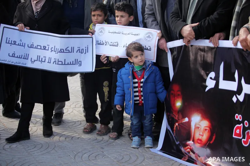 Palestinians hold placards during a demonstration against the ongoing electricity shortages in Gaza city on January 15, 2017. Power shortages in the Palestinian enclave have occurred repeatedly in recent weeks, with home...