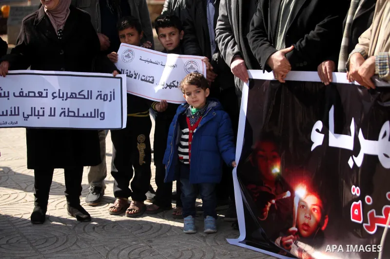 Palestinians hold placards during a demonstration against the ongoing electricity shortages in Gaza city on January 15, 2017. Power shortages in the Palestinian enclave have occurred repeatedly in recent weeks, with home...
