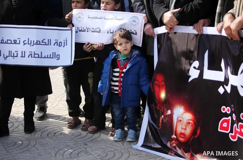 Palestinians hold placards during a demonstration against the ongoing electricity shortages in Gaza city on January 15, 2017. Power shortages in the Palestinian enclave have occurred repeatedly in recent weeks, with home...