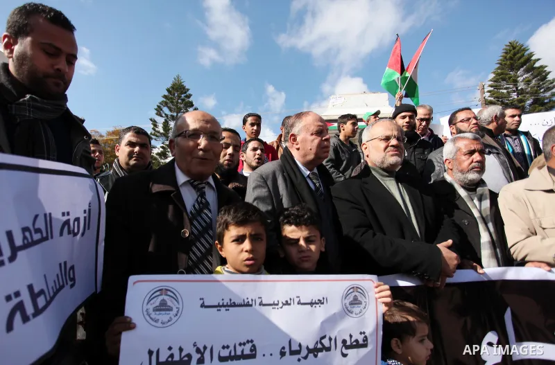 Palestinians hold placards during a demonstration against the ongoing electricity shortages in Gaza city on January 15, 2017. Power shortages in the Palestinian enclave have occurred repeatedly in recent weeks, with home...