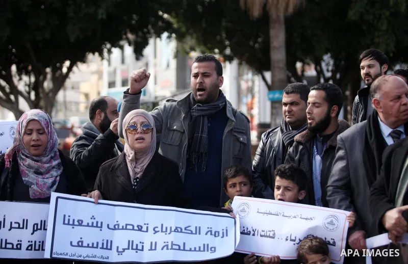 Palestinians hold placards during a demonstration against the ongoing electricity shortages in Gaza city on January 15, 2017. Power shortages in the Palestinian enclave have occurred repeatedly in recent weeks, with home...