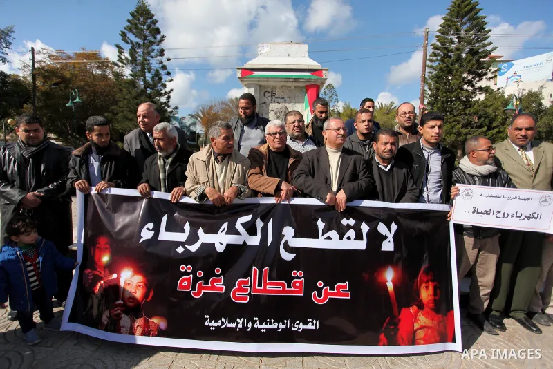 Palestinians hold placards during a demonstration against the ongoing electricity shortages in Gaza city on January 15, 2017. Power shortages in the Palestinian enclave have occurred repeatedly in recent weeks, with home...