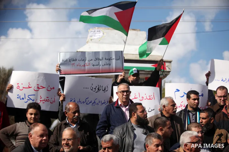 Palestinians hold placards during a demonstration against the ongoing electricity shortages in Gaza city on January 15, 2017. Power shortages in the Palestinian enclave have occurred repeatedly in recent weeks, with home...