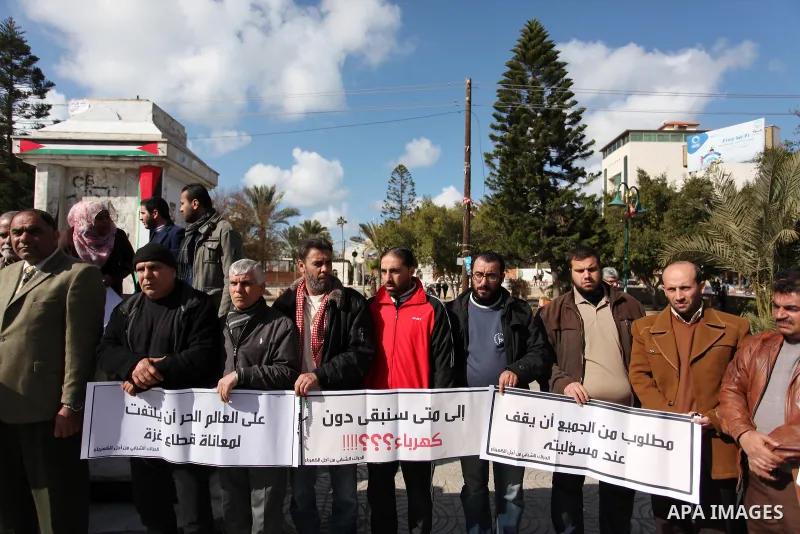 Palestinians hold placards during a demonstration against the ongoing electricity shortages in Gaza city on January 15, 2017. Power shortages in the Palestinian enclave have occurred repeatedly in recent weeks, with home...