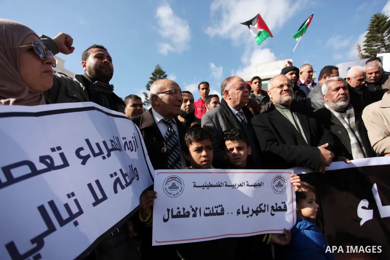 Palestinians hold placards during a demonstration against the ongoing electricity shortages in Gaza city on January 15, 2017. Power shortages in the Palestinian enclave have occurred repeatedly in recent weeks, with home...