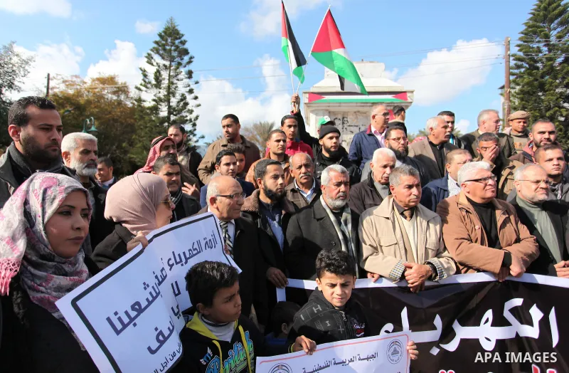 Palestinians hold placards during a demonstration against the ongoing electricity shortages in Gaza city on January 15, 2017. Power shortages in the Palestinian enclave have occurred repeatedly in recent weeks, with home...