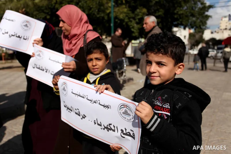 Palestinians hold placards during a demonstration against the ongoing electricity shortages in Gaza city on January 15, 2017. Power shortages in the Palestinian enclave have occurred repeatedly in recent weeks, with home...