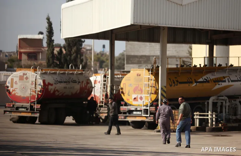 Palestinian men walk as a fuel tanker arrives at Gaza's power plan in Nuseirat in the central Gaza Strip January 16, 2017. Photo by Ashraf Amra