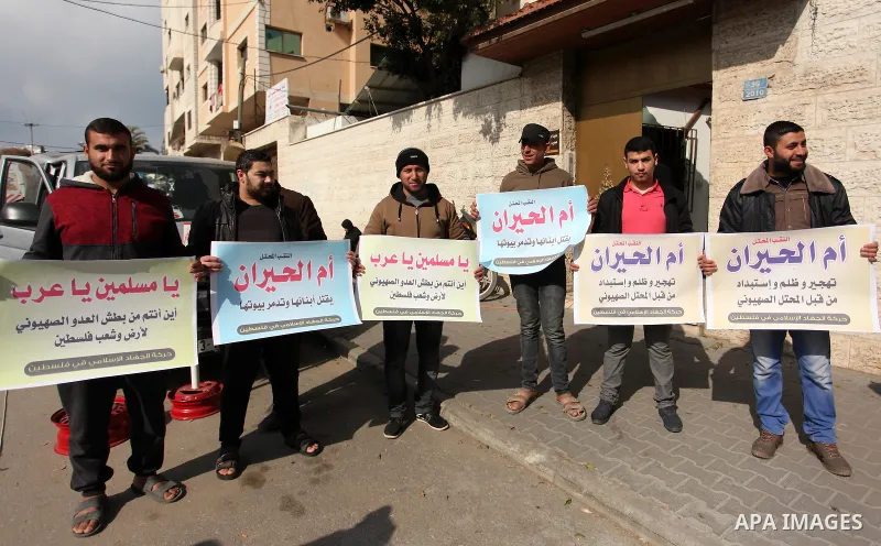 Palestinian supporters of the Islamic Jihad Movement, hold placards during a protest after Israeli police raided the unrecognized Bedouin village of Umm al-Hiran to evacuate residents in order to demolish their homes, in...