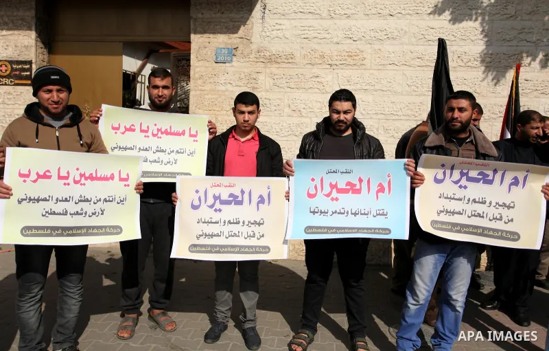 Palestinian supporters of the Islamic Jihad Movement, hold placards during a protest after Israeli police raided the unrecognized Bedouin village of Umm al-Hiran to evacuate residents in order to demolish their homes, in...