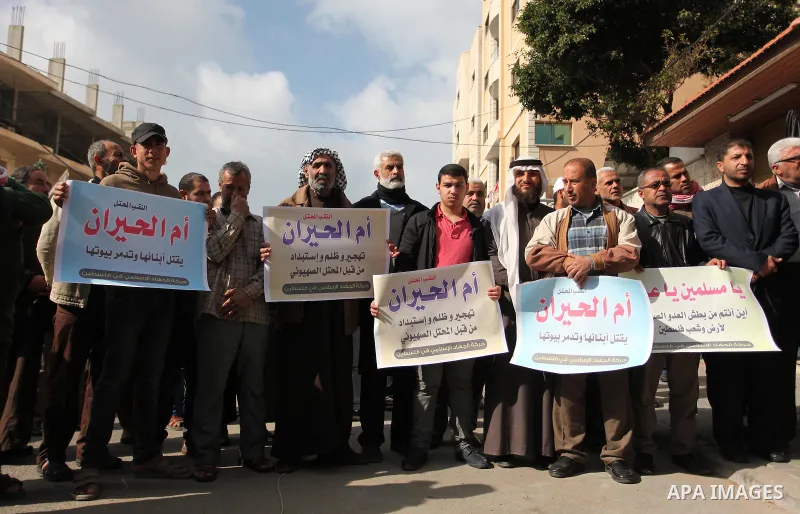 Palestinian supporters of the Islamic Jihad Movement, hold placards during a protest after Israeli police raided the unrecognized Bedouin village of Umm al-Hiran to evacuate residents in order to demolish their homes, in...