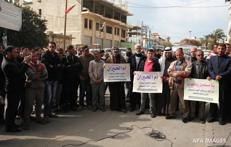 Palestinian supporters of the Islamic Jihad Movement, hold placards during a protest after Israeli police raided the unrecognized Bedouin village of Umm al-Hiran to evacuate residents in order to demolish their homes, in...