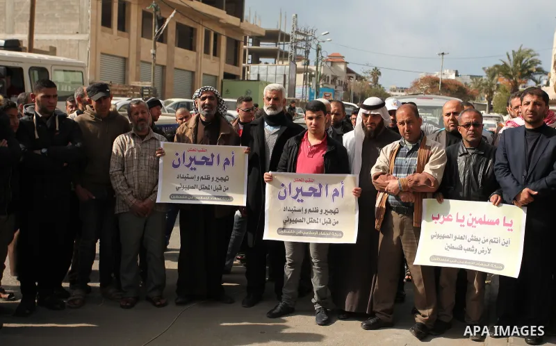 Palestinian supporters of the Islamic Jihad Movement, hold placards during a protest after Israeli police raided the unrecognized Bedouin village of Umm al-Hiran to evacuate residents in order to demolish their homes, in...