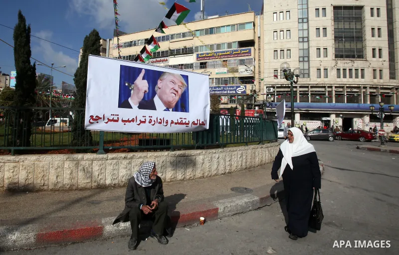 A Palestinian woman walks past a banner against a promise by U.S. President-elect Donald Trump to relocate the U.S. embassy to Jerusalem, in the West Bank city of Nablus January 19, 2017. Photo by Nedal Eshtayah