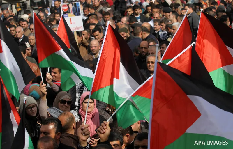 Palestinians hold palestine flags during a demonstration against proposed plans by President-elect Donald Trump to move the US embassy in Israel to Jerusalem, in the West Bank city of Nablus, on January 19, 2017. Photo b...