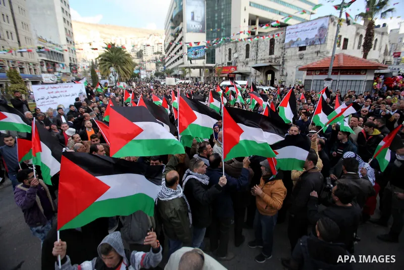 Palestinians hold palestine flags during a demonstration against proposed plans by President-elect Donald Trump to move the US embassy in Israel to Jerusalem, in the West Bank city of Nablus, on January 19, 2017. Photo b...