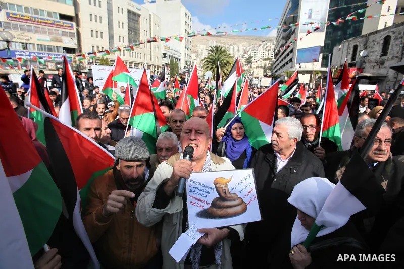 Palestinians hold palestine flags during a demonstration against proposed plans by President-elect Donald Trump to move the US embassy in Israel to Jerusalem, in the West Bank city of Nablus, on January 19, 2017. Photo b...