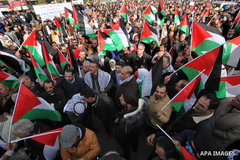 Palestinians hold palestine flags during a demonstration against proposed plans by President-elect Donald Trump to move the US embassy in Israel to Jerusalem, in the West Bank city of Nablus, on January 19, 2017. Photo b...