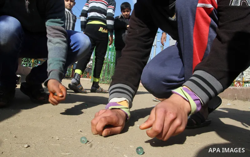 Palestinian children play marbles in a street in Rafah in the southern Gaza strip on January 19, 2017. Photo by Abed Rahim Khatib