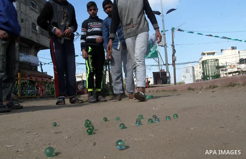 Palestinian children play marbles in a street in Rafah in the southern Gaza strip on January 19, 2017. Photo by Abed Rahim Khatib