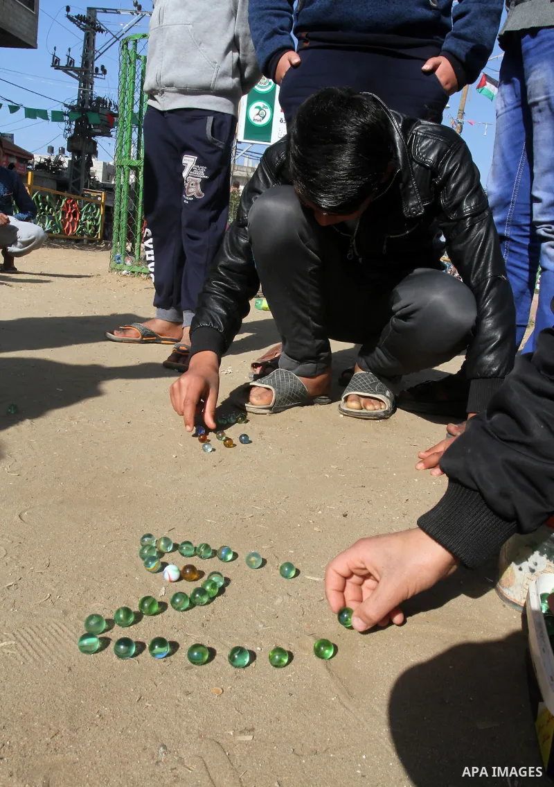Palestinian children play marbles in a street in Rafah in the southern Gaza strip on January 19, 2017. Photo by Abed Rahim Khatib