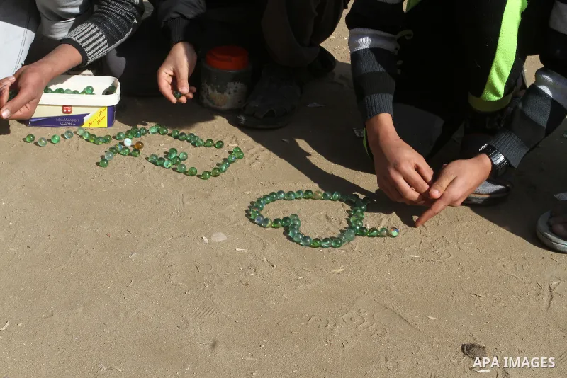 Palestinian children play marbles in a street in Rafah in the southern Gaza strip on January 19, 2017. Photo by Abed Rahim Khatib