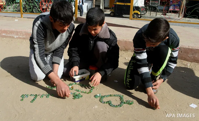 Palestinian children play marbles in a street in Rafah in the southern Gaza strip on January 19, 2017. Photo by Abed Rahim Khatib