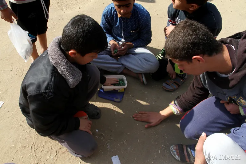 Palestinian children play marbles in a street in Rafah in the southern Gaza strip on January 19, 2017. Photo by Abed Rahim Khatib