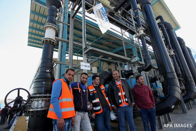Palestinian workers pose for a photo during the inauguration ceremony of The First Phase of the Seawater Desalination Plant-Southern Gaza completed with generous support from the European union Implemented by UNICEF in p...