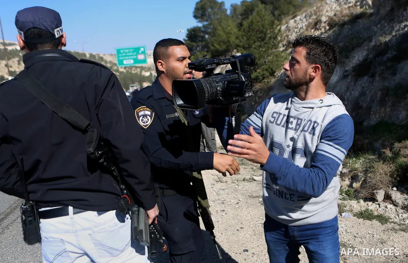Israeli policeman argues with a Palestinian cameraman during a demonstration against the construction of Jewish settlements in the occupied West Bank and against US President-elect Donald Trump, on January 20, 2017, near...