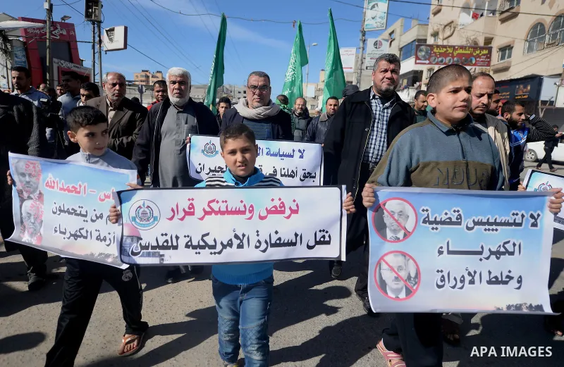 Palestinian children hold placards during a protest against proposed plans by President-elect Donald Trump to move the US embassy in Israel to Jerusalem, and against the power crisis, and to show solidarity with Palestin...
