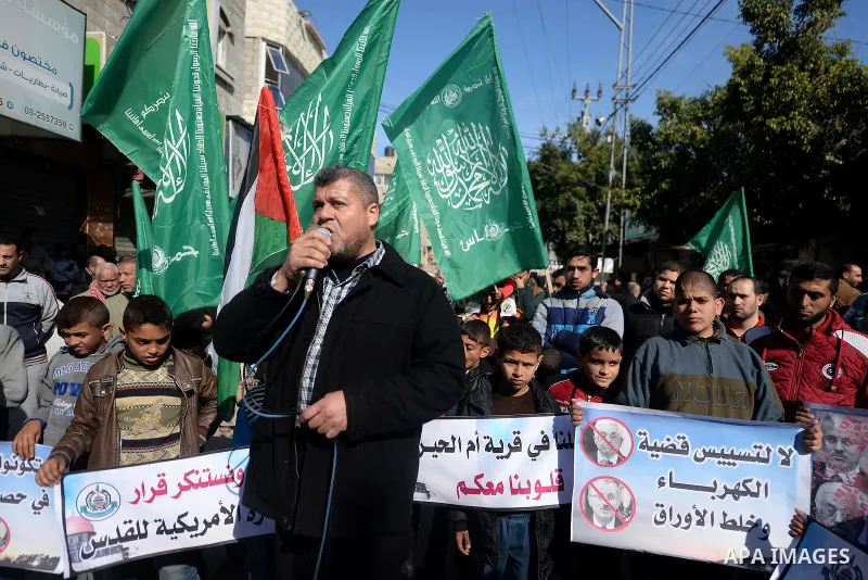Palestinian children hold placards during a protest against proposed plans by President-elect Donald Trump to move the US embassy in Israel to Jerusalem, and against the power crisis, and to show solidarity with Palestin...