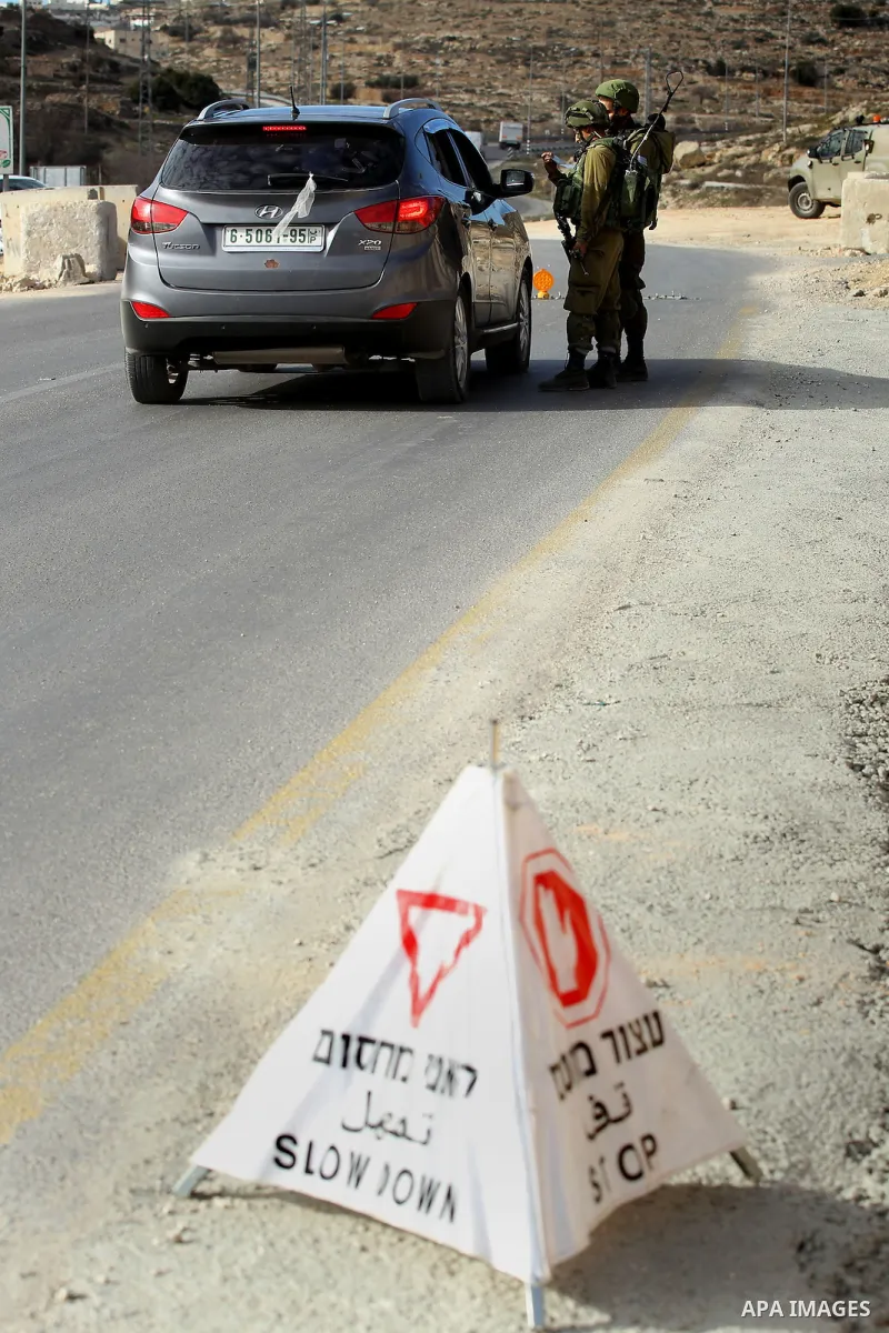 Israeli security forces inspect Palestinian cars in West Bank village of Sair, east of Hebron, on January 20, 2017. Photo by Wisam Hashlamoun
