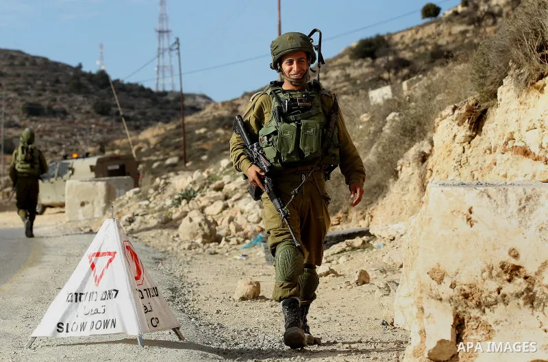 Israeli security forces inspect Palestinian cars in West Bank village of Sair, east of Hebron, on January 20, 2017. Photo by Wisam Hashlamoun