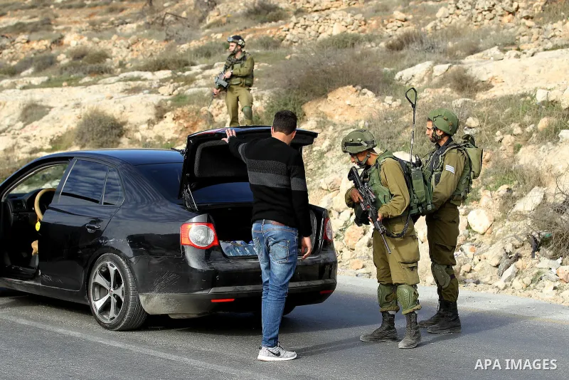 Israeli security forces inspect Palestinian cars in West Bank village of Sair, east of Hebron, on January 20, 2017. Photo by Wisam Hashlamoun