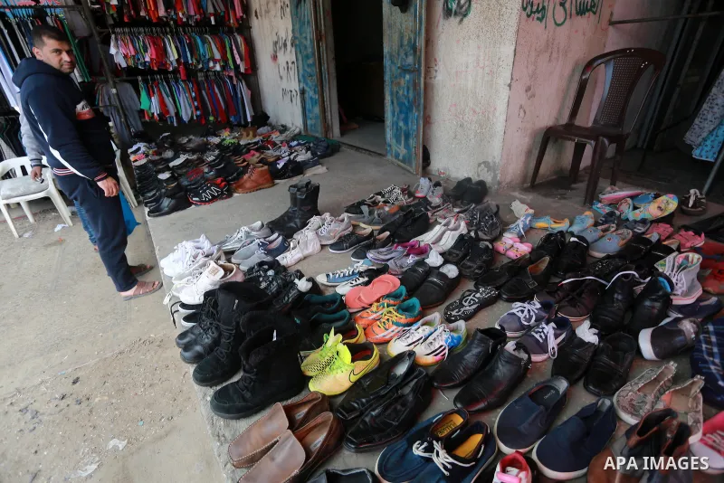A Palestinian man looks at second hand clothes at a market in Gaza city, on January 21, 2017.Due to the current economic situation in Gaza Strip, many of the Palestinians resort to meet their needs of used goods. Photo b...