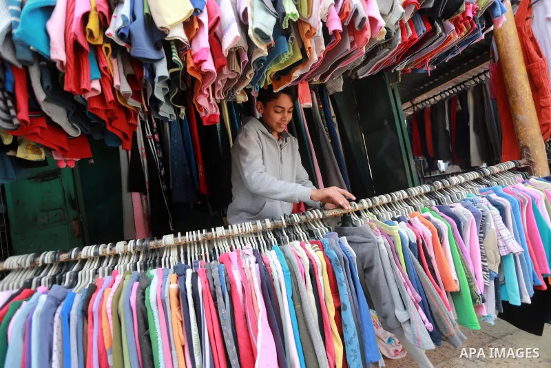 A Palestinian man looks at second hand clothes at a market in Gaza city, on January 21, 2017.Due to the current economic situation in Gaza Strip, many of the Palestinians resort to meet their needs of used goods. Photo b...
