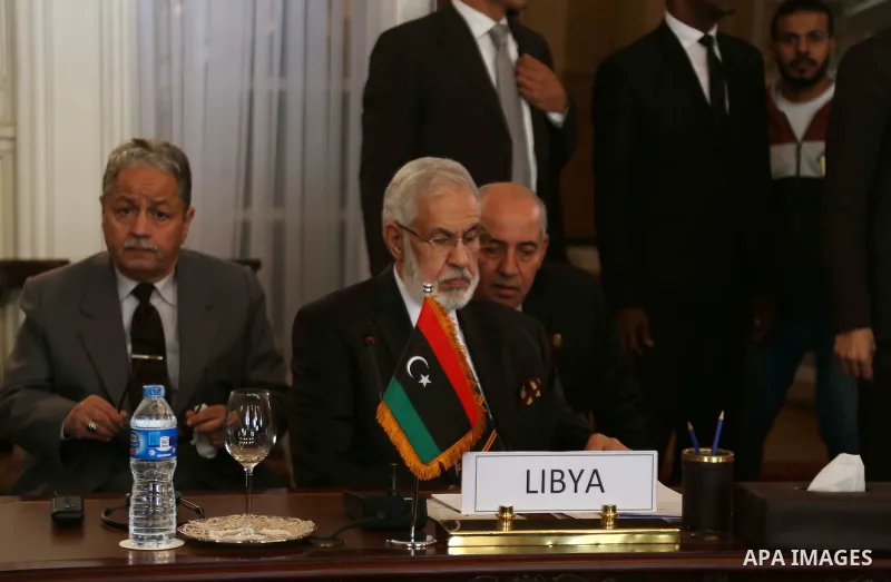 Libyan Foreign Minister, Mohamed Taher Siala, top center, attends a ministerial meeting of countries neighboring Libya which include Egypt, Tunisia, Algeria, Sudan, Niger and Chad, as well as United Nations envoy, Martin...