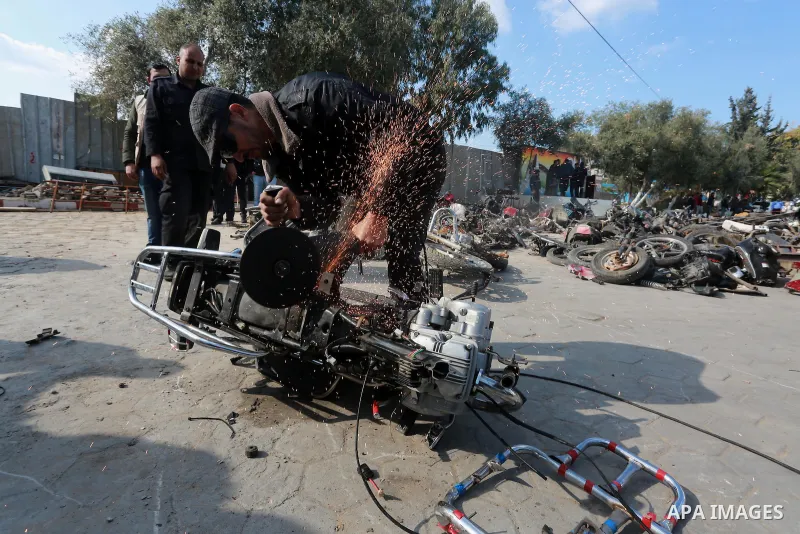 A Palestinian policeman destroys illegal motorcycles in Gaza city on January 22, 2017. According to Palestinian traffic police more than 70 motorcycle and 1500 Gas device will be destroyed. Photo by Mohammed Asad